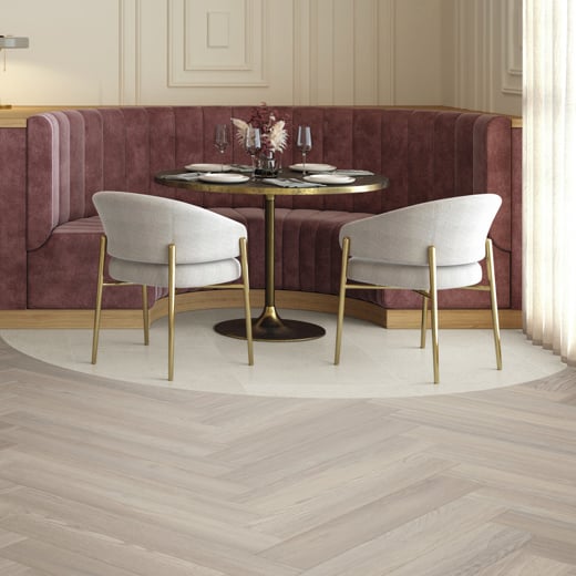 Karndean Designflooring Caliza Classico stone vinyl tiles and Bellota Oak wood herringbone flooring in a hospitality commercial environment